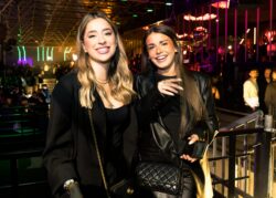 Due ragazze sorridenti in nero sulla balconata del locale