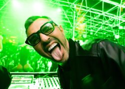 Dj sorridente in consolle con luci verdi