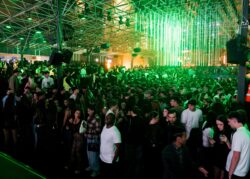 Pista affollata sotto luci verdi e la struttura metallica