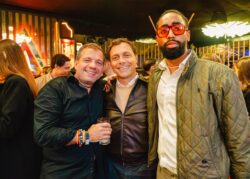 Tre ospiti sorridenti in posa nella zona bar