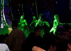 Performer ballano sul palco in luce verde