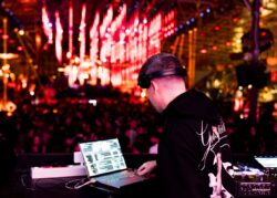 Dj al computer davanti alle luci rosse della pista