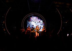 Performer e dj sul palco incorniciati da anelli luminosi