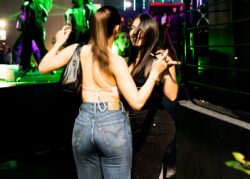 Due ragazze ballano vicino al palco con luci verdi